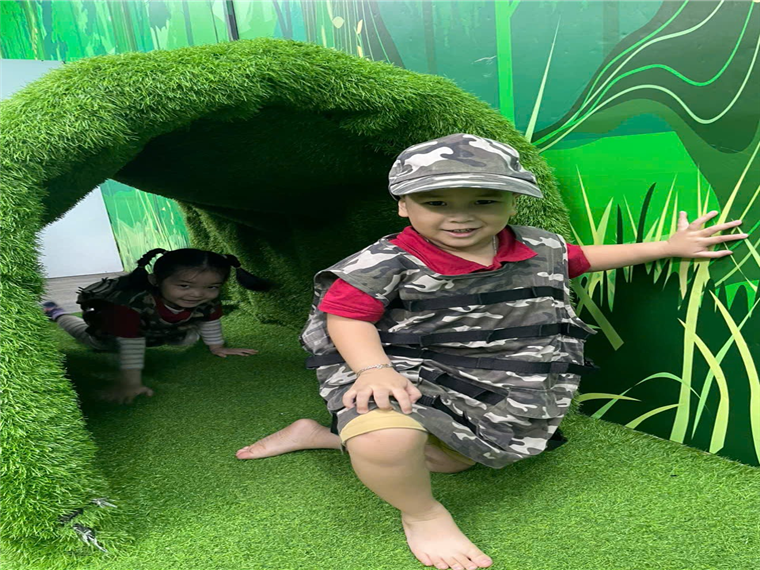 A child and child playing in a tunnel

Description automatically generated