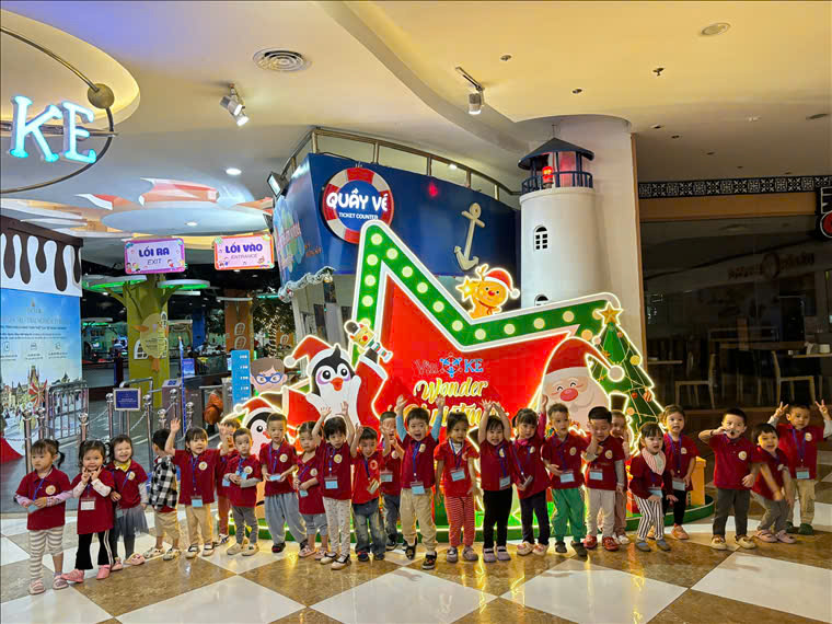 A group of children standing in front of a large sign

Description automatically generated