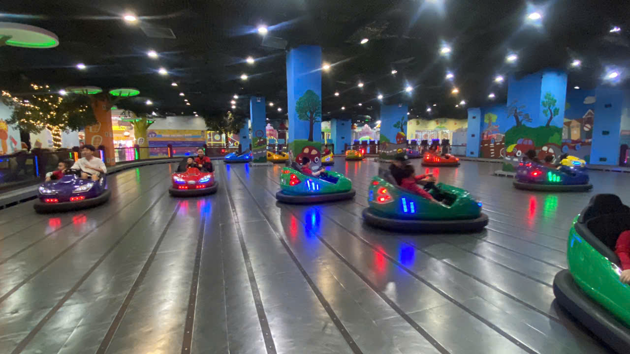 A group of people in bumper cars

Description automatically generated