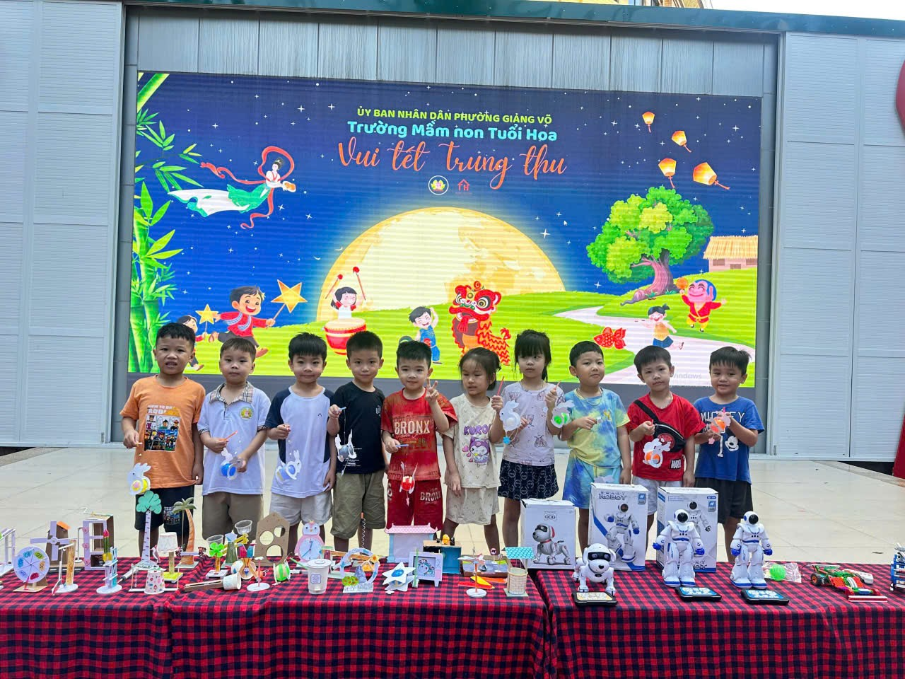 A group of children standing in front of a table with toys

Description automatically generated