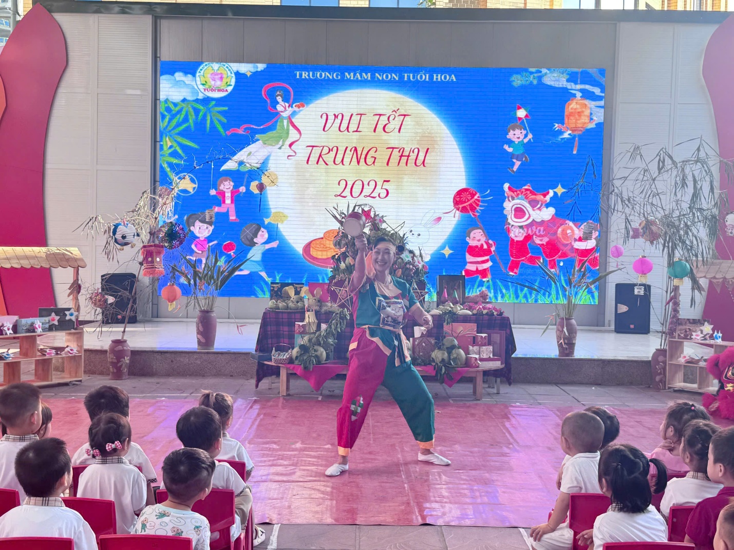 A person on a stage with a group of children

AI-generated content may be incorrect.