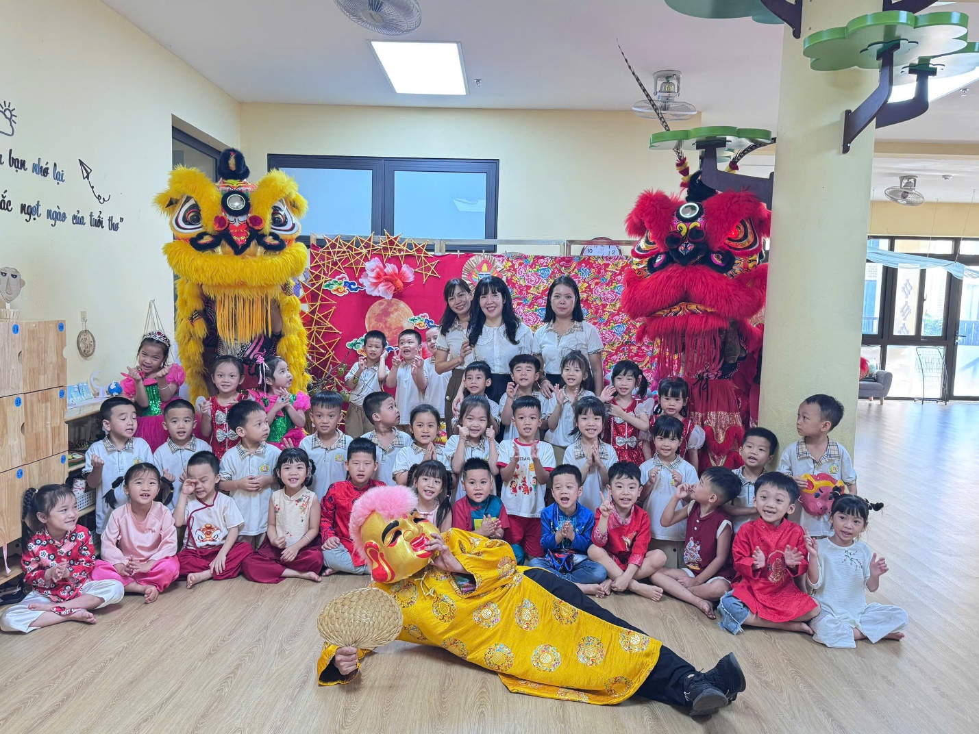 A group of children and a person in a room with a lion dance

AI-generated content may be incorrect.