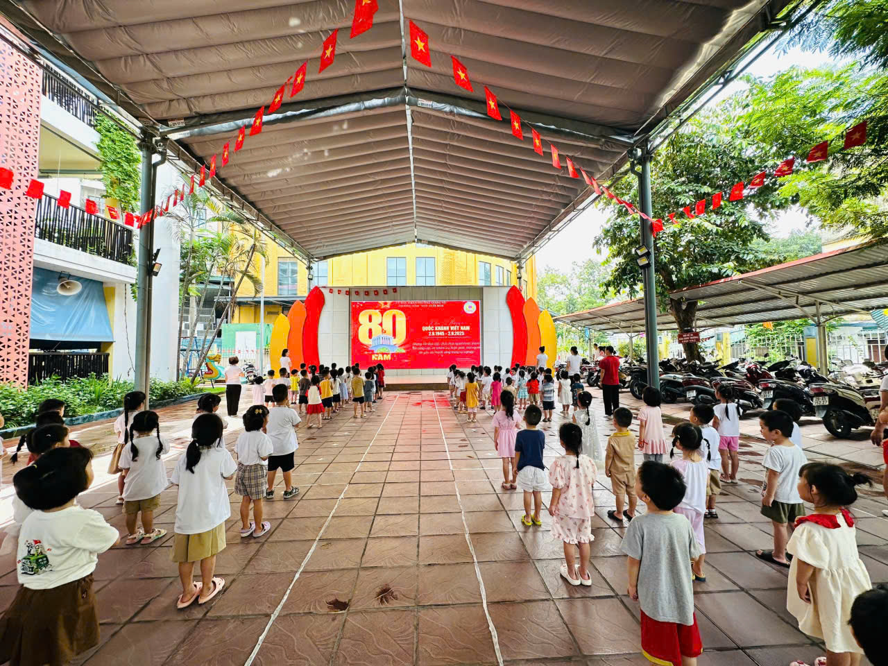 A group of children standing in a courtyard

Description automatically generated