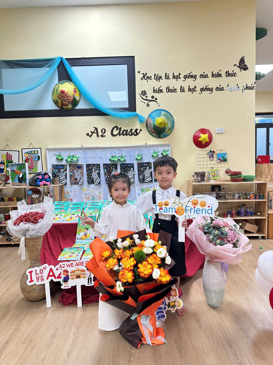 A child and child holding flowers in a classroom

Description automatically generated