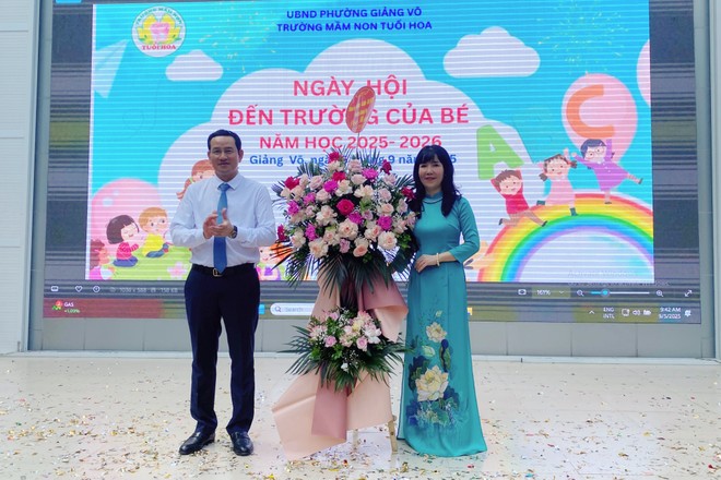 Đồng chí Cồ Như Dũng, Phó Bí thư Đảng uỷ, Chủ tịch UBND phường Giảng Võ tặng hoa chúc mừng trường Mầm non Tuổi hoa