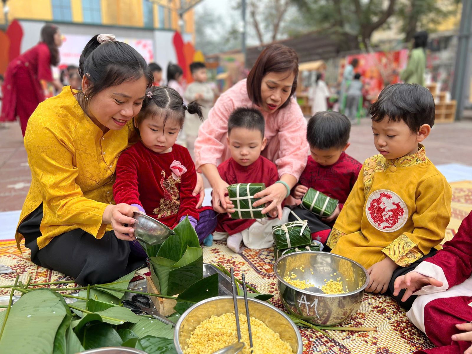 Các bé được cô giáo hướng dẫn từng bước gói bánh chưng