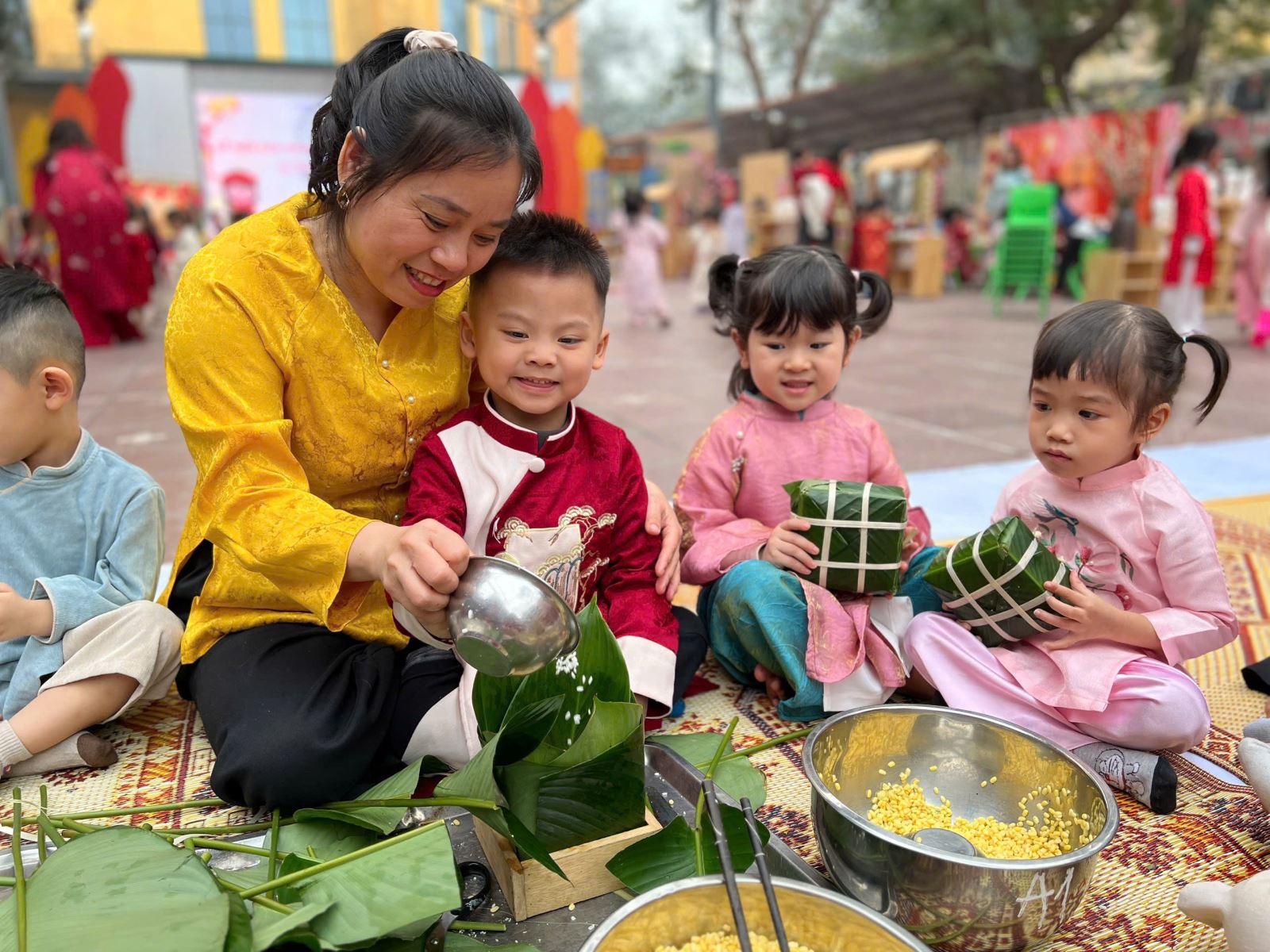 Nụ cười của bé khi nhìn những hạt gạo nếp trắng tinh rơi rơi vào khuôn lá