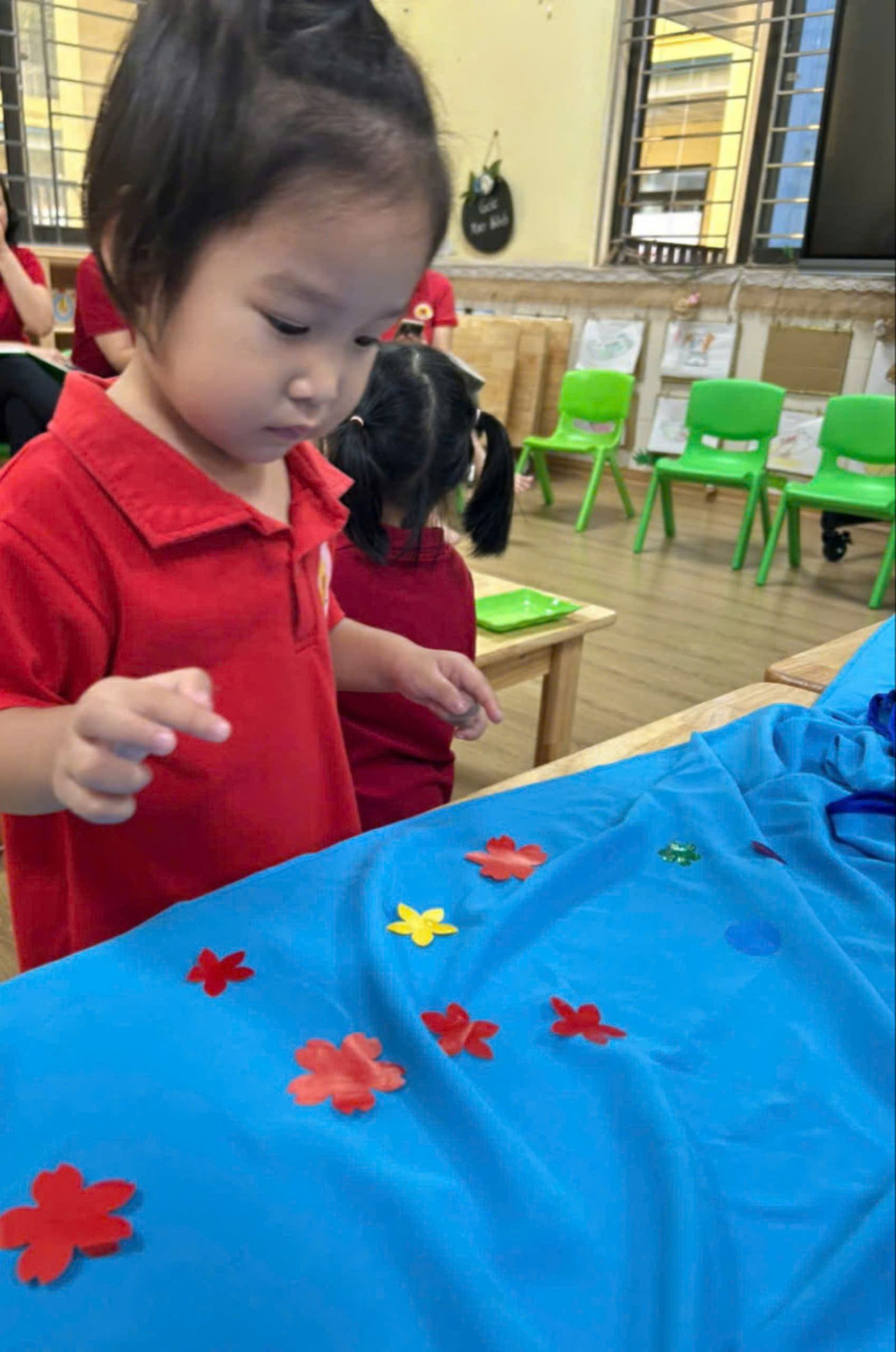 Bé say sưa ngắm bông hoa mình vừa dán