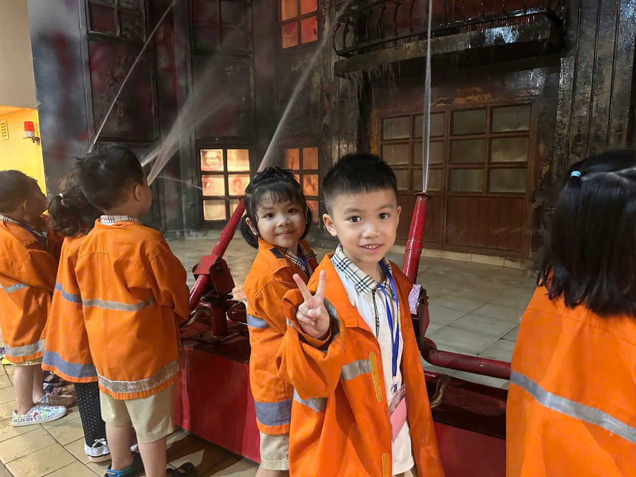 A group of children in orange jackets

Description automatically generated
