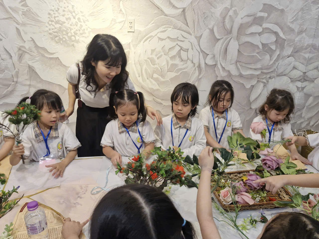 A group of children in a room with a person

Description automatically generated