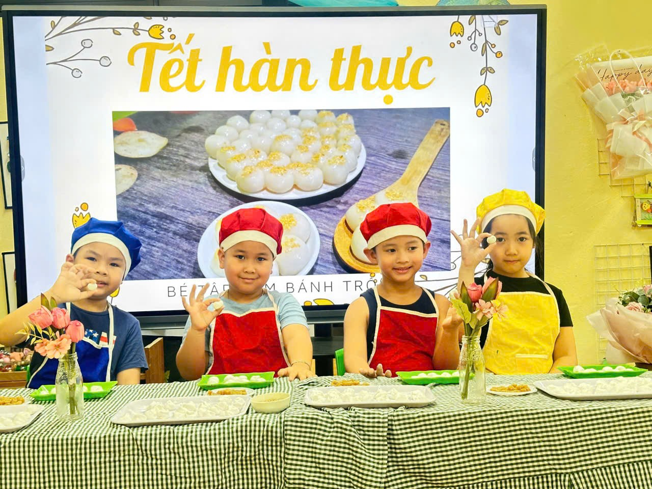 A group of kids wearing aprons and hats sitting at a table

Description automatically generated