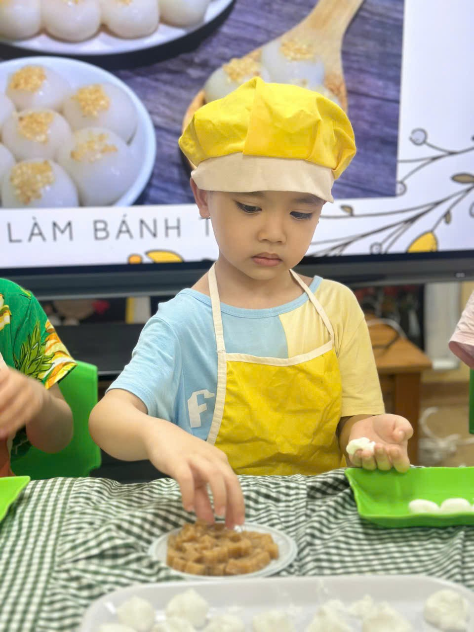A child wearing a chef hat and apron

Description automatically generated